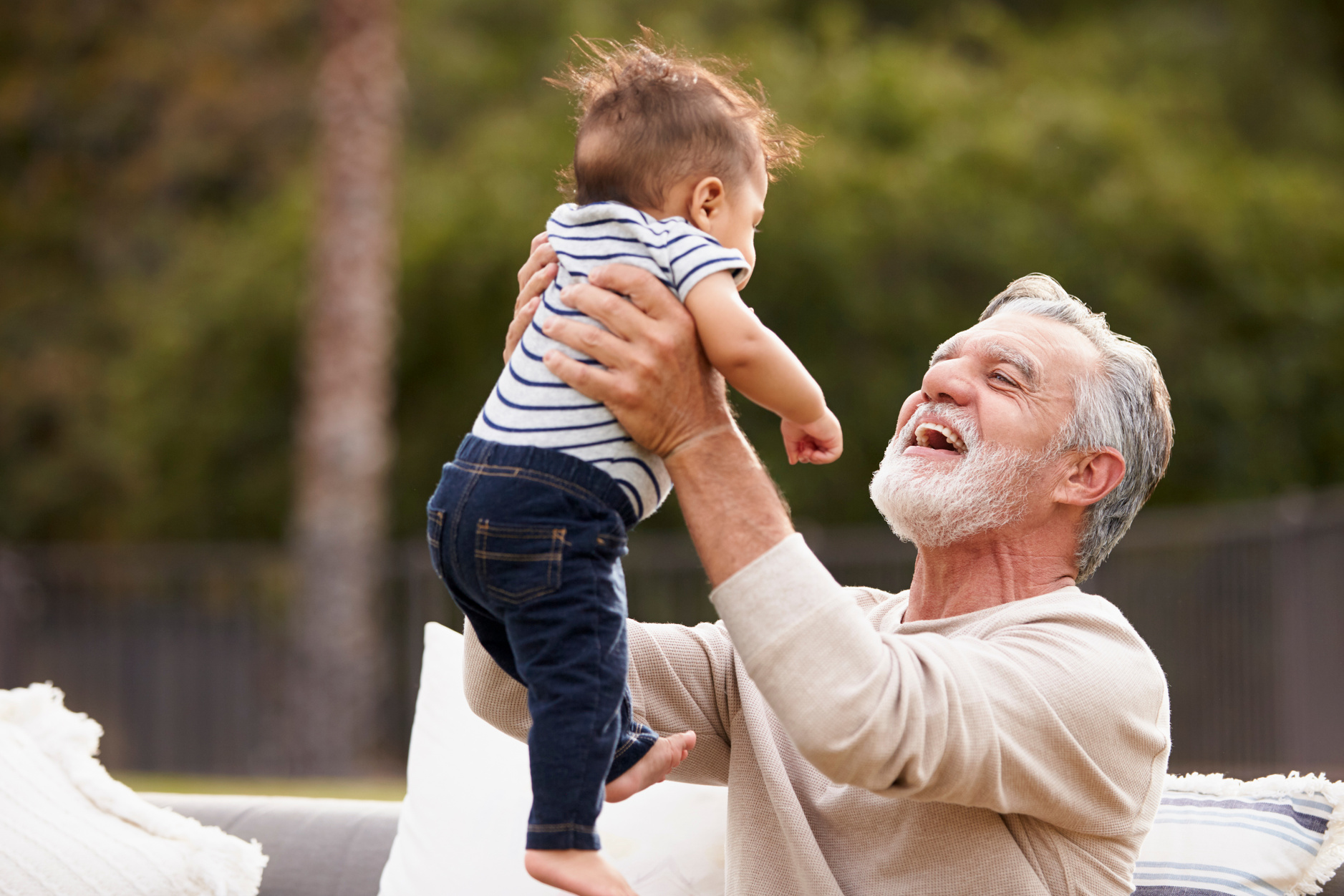 Grandfather Lifting Grandchild Outdoors